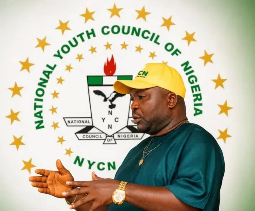 Comr. Dr Atigwe Henry Ifeanyi speaking in front of the National Youth Council of Nigeria emblem