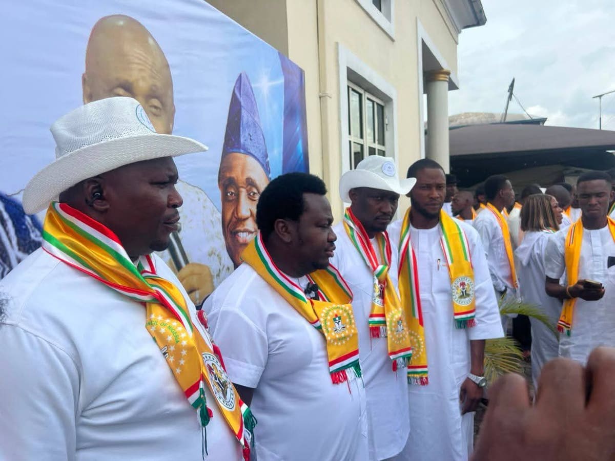NYCN South East leaders in white attire and council sashes standing in front of a campaign banner